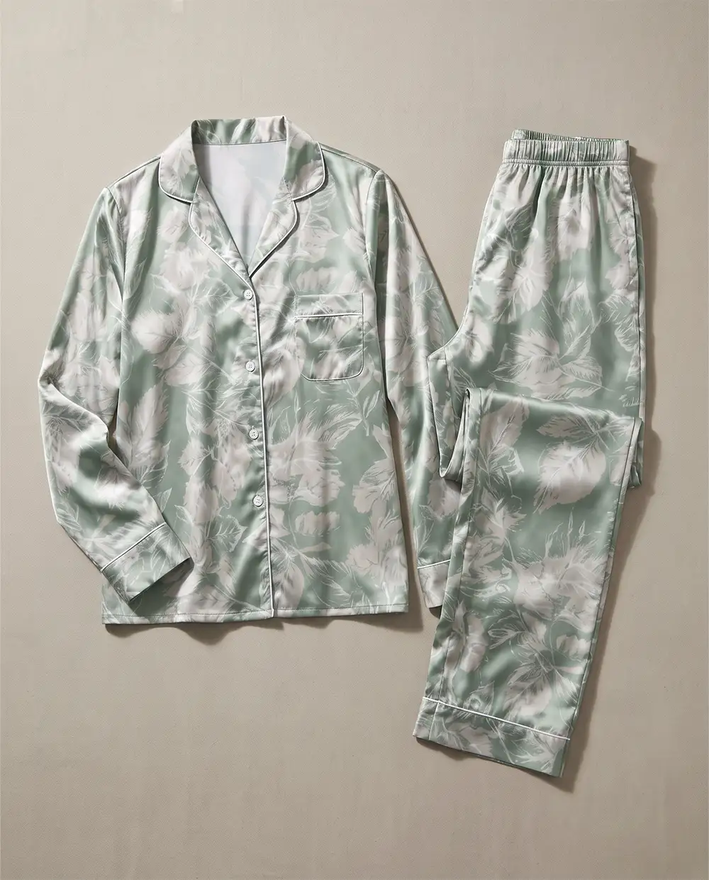 two-piece-green-satin-pajama-flat-lay طقم بيجامة ساتان قطعتين قميص وبنطلون مفرود على سطح بيج